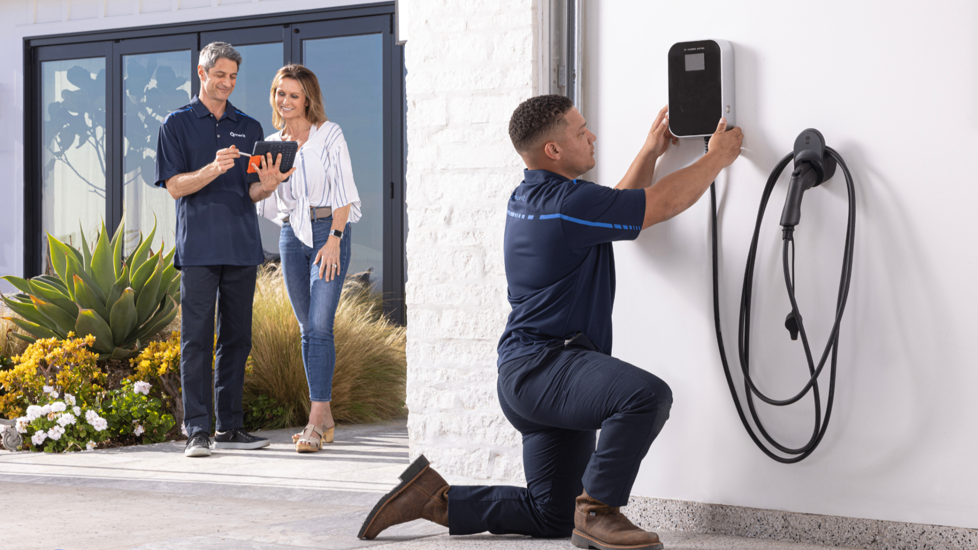 Licensed Boise electrician installing a Level 2 EV charger at a Treasure Valley home while homeowners review the install on a tablet